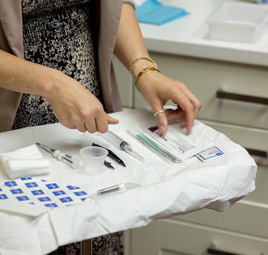 Healthcare provider preparing a hormone pellet insertion tray with sterile supplies