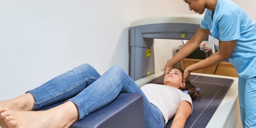 Young Nurse Preparing Woman fo Bone Density Scan Young Nurse Preparing Woman fo Bone Density Scan